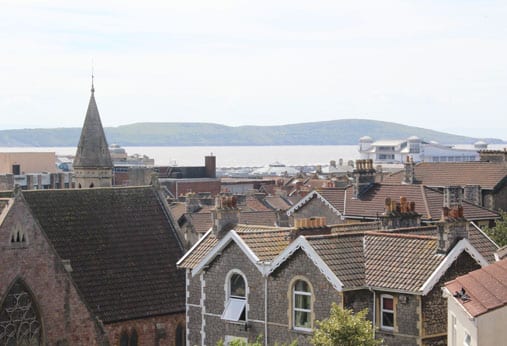 view overlooking rooftops with estuary and hills in the background